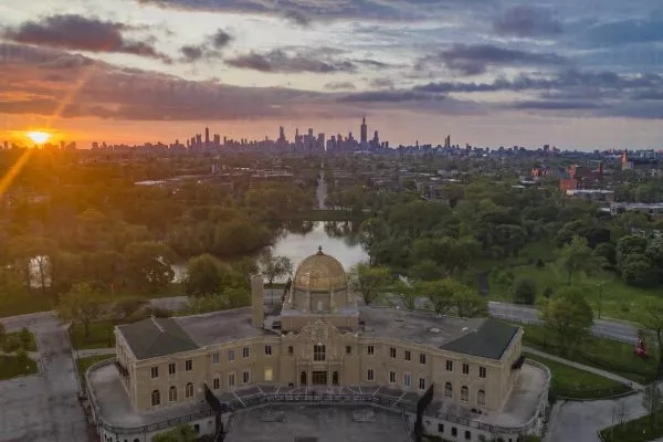 Aerial view of Garfield Park Gold Dome Field House in Garfield Park with city downtown in background at sunset, Chicago, Illinois, United States.